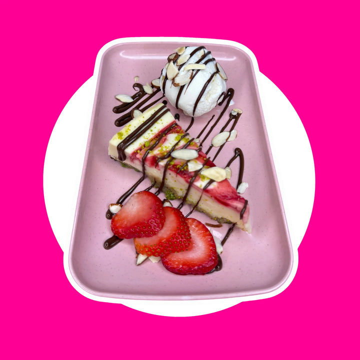 Strawberry Cheesecake served with a scoop of creamy vanilla ice cream, drizzled with rich Nutella sauce, and finished with a sprinkle of shaved almonds